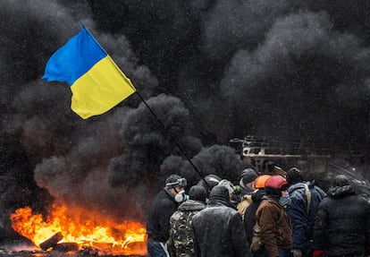 Los manifestantes ucranianos queman neumáticos de automóviles durante una protesta masiva en Kiev, contra el gobierno de Ucrania