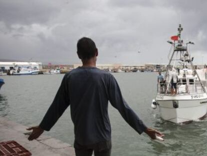 Un vecino de Barbate recibe en el puerto a uno de los pesqueros que regresaron este jueves de Marruecos.