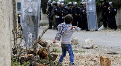 Un ni&ntilde;o tira una piedra a soldados isarel&iacute;es cerca de Nabl&uacute;s.
 