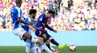 Messi chuta a puerta frente a dos rivales del Espanyol.