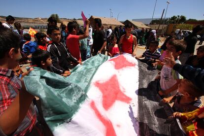 Un grupo de niños sirios desplegan una bandera de su país en el CETI de Melilla en 2014