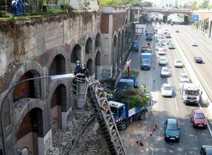 Los bomberos sanean el revestimiento de ladrillo del puente.