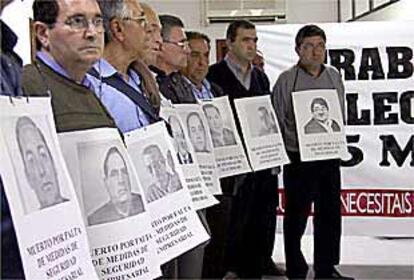 Antiguos trabajadores de Electroquímica, ayer en Jaén, con fotos de sus compañeros muertos.