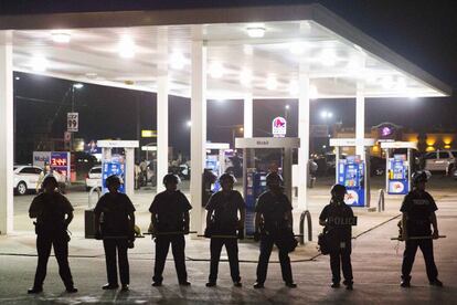 Agentes policiales hacen guardia en una gasolinera después de la protesta.
