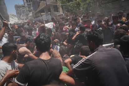 Palestinos luchan por coger la ayuda humanitaria lanzada en paracaídas sobre Gaza.