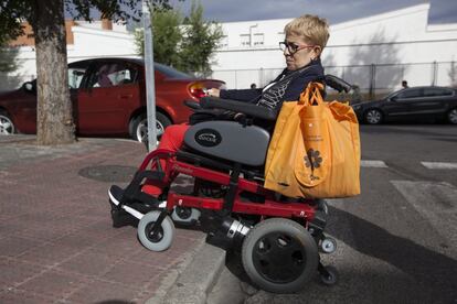 Maite baja de espaldas la acera de su casa, que no tiene rampa, con la silla de ruedas eléctrica. Ha roto cuatro ruedas debido al impacto y ahora lleva neumáticos macizos. "Tengo miedo de caerme de espaldas o de que me atropellen", explica.