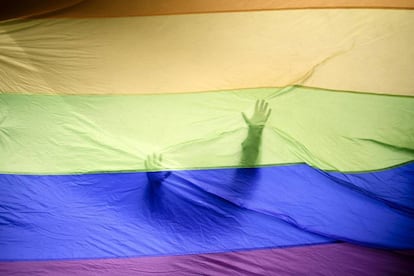 Um homem atrás de uma bandeira LGBTQ gigante em um protesto em Berlim, em setembro de 2017.