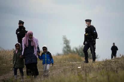 Oficiales de policía franceses inspeccionan la zona de asentamientos de migrantes en Calais, Francia, el 14 de octubre de 2021.