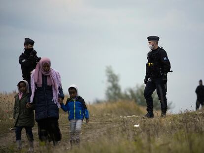 Oficiales de policía franceses inspeccionan la zona de asentamientos de migrantes en Calais, Francia, el 14 de octubre de 2021.