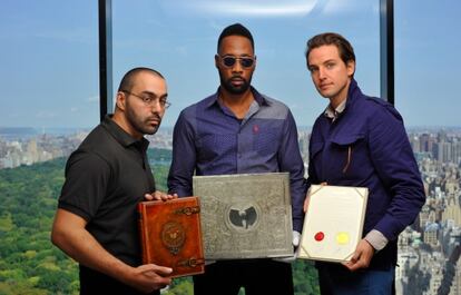 À esquerda, Cilvaringz e RZA, dois dos membros do Wu-Tang, com o livro e o disco. À direita está Alexander Gilkers, da casa digital de leilões que pôs o álbum à venda. A fotografia é uma das publicadas pela casa de leilões. Você pode entrar no microsite do leilão clicando na imagem