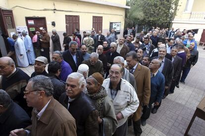 Un grupo de hombres espera para participar en el referéndum sobre la nueva Constitución en el barrio de Abassyia, en El Cairo (Egipto).