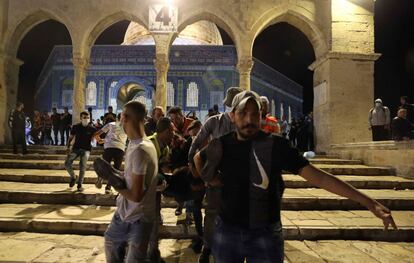 Más de un centenar de palestinos habían resultado heridos el 23 de abril en anteriores enfrentamientos con la policía durante Ramadán ante la Puerta de Damasco de Jerusalén. En medio de una oleada de incidentes sucesivos, esa noche protestaban contra una marcha de cientos de ultraderechistas israelíes que se habían aproximado hasta el principal acceso al barrio musulmán de la Ciudad Vieja al grito de “¡muerte a los árabes!”. En la imagen, traslado de un herido palestino en la mezquita Al-Aqsa, en la noche de este viernes.