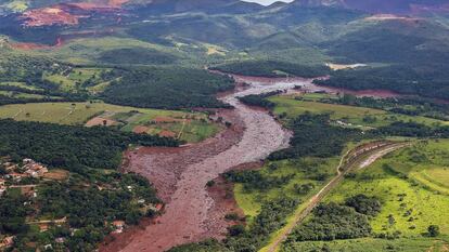 Vista aérea da devastação em Brumadinho. Ao fundo, a Serra Três Irmãos.