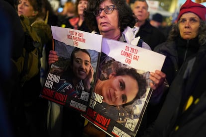 Una mujer muestra durante una manifestación en la noche del sábado en Tel Aviv carteles con la imagen de dos de las rehenes capturadas durante el ataque de Hamás a Israel el pasado 7 de octubre, donde fueron asesinadas, según las autoridades locales, unas 1.200 personas y secuestradas más de dos centenares.