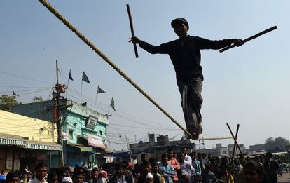 Un joven acróbata realiza una función en un mercado de Nueva Delhi (India).