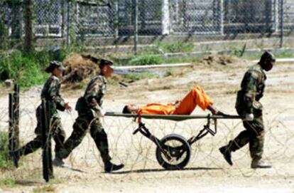 Varios soldados llevan a un detenido en la base estadounidense de Guantánamo (Cuba) a un interrogatorio.
