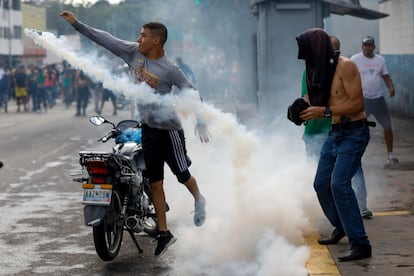 Un manifestante arroja una bomba de gas a la policía durante las manifestaciones contra los resultados oficiales de las elecciones presidenciales. 
