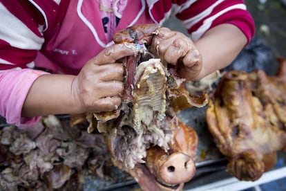 Vendedoras de hornado, plato típico del Ecuador,. Los chanchos o cerdos se asan enteros a fuego de brasa que luego será vendido por porciones.En el mercado de San Roque la asociación de hornados de Salgonqui lleva sus productos de madrugada.