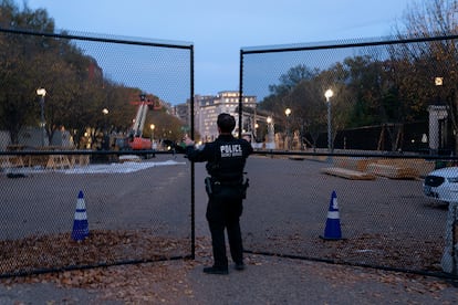 A member of the United States Secret Service closes a gate in the security fence on Pennsylvania Avenue near the White House.