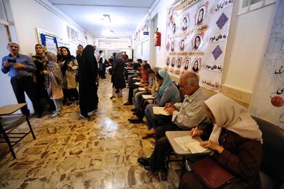 Un grupo de iraníes preparan su voto en un centro electoral al norte de Teherán.