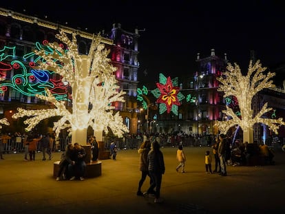 Personas caminan entre decoraciones festivas en el Zócalo de la capital mexicana, en diciembre de 2021.