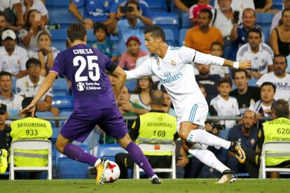El delantero portugués del Real Madrid Cristiano Ronaldo (d) lucha el balón con Federico Chiesa, delantero de la Fiorentina.