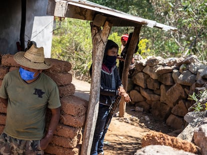 Memo, a la izquierda, se recarga sobre la pared de una trinchera de policías comunitarios en Tula, en el municipio de Chilapa, en Guerrero, el 24 de febrero.