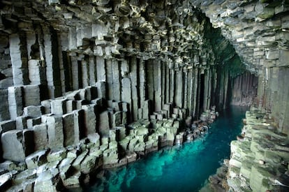 Como si fueran las oscuras fauces del infierno, esta cueva se abre al mar azul turquesa y se adentra 85 metros en la gris roca volcánica de la isla escocesa de Staffa, en el archipiélago de las Hébridas. Lo que hace aún más surrealista la visión son los cientos de columnas de basalto a ambos lados de la entrada a la caverna. Es como si un artista hubiera diseñado esta isla y no hubiera surgido de manera natural. Gracias a su singular belleza, este lugar ya tuvo en el pasado muchos visitantes de postín, por ejemplo, Julio Verne y Felix Mendelssohn Bartholdy. Este último quedó tan impactado que tras la visita compuso su célebre obra 'Las Hébridas' (1830). <br></br> Más información: nts.org.uk