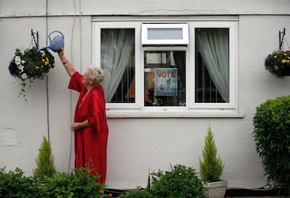 Una anciana que apoya el 'Brexit' riega las plantas de su casa a las afueras de Oxford, Inglaterra.