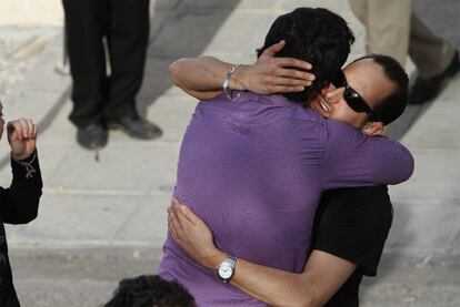 Un amigo da el psame en el tanatorio de Lorca al hijo sordomudo de una de las fallecidas, con camisa negra.