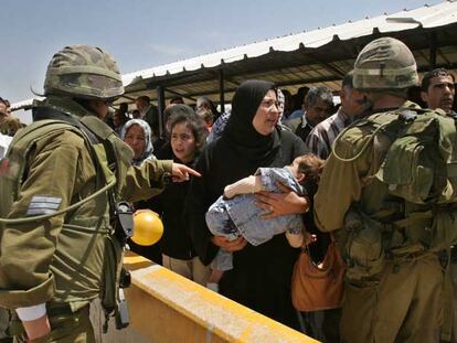 Soldados israelíes controlan el paso de palestinos en el puesto de control de Hawara, en las afueras de la ciudad cisjordana de Nablus.