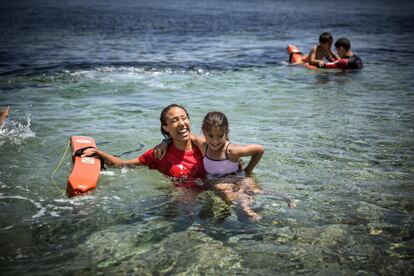 En 2015 llegaron por mar a Grecia más de 850.000 personas, de las que más de 500.000 desembarcaron en la isla de Lesbos. En la iamgen, una voluntaria del grupo español 'Proem-Aid' enseñando a nadar a una niña refugiada en la isla de Lesbos (Grecia).