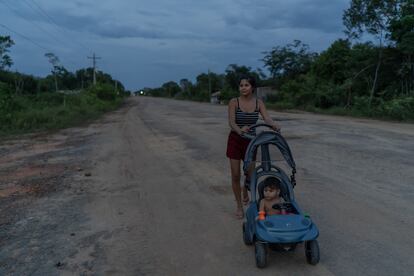 Una joven pasea a su hijo por el arcén de la carretera amazónica BR319, en Manicoré, en octubre pasado.
