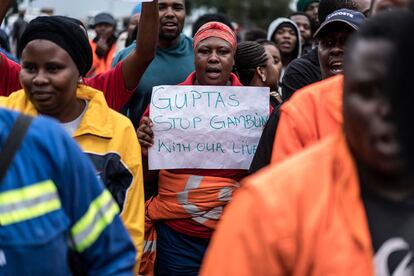 Empleados y contratistas de la mina de carbón Optimum, propiedad de la controvertida familia Gupta, se manifiestan con una pancarta en la que se lee "Guptas, dejen de jugar con nuestras vidas" frente a las puertas de la mina en Hendrina, Sudáfrica, en febrero de 2018.