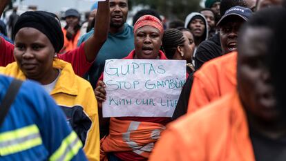 Empleados y contratistas de la mina de carbón Optimum, propiedad de la controvertida familia Gupta, se manifiestan con una pancarta en la que se lee "Guptas, dejen de jugar con nuestras vidas" frente a las puertas de la mina en Hendrina, Sudáfrica, en febrero de 2018.
