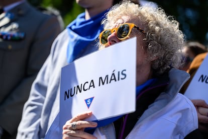 Una mujer sostiene un cartel con el lema "Nunca más".