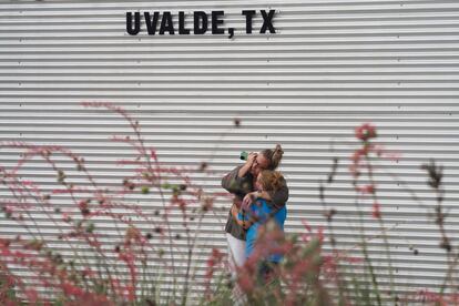 Una mujer lloraba y abrazaba a una niña mientras hablaba por teléfono el martes, en el exterior del Centro Cívico Willie de Leon, en Uvalde, Texas, tras el tiroteo que mató a 19 niños y dos profesoras en un colegio. El centro ofrece asistencia psicológica. 