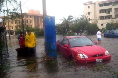 Habitantes de Cancún en una calle anegada durante el paso del huracán Wilma.