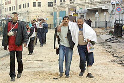 Unos palestinos heridos en los enfrentamientos con las tropas israelíes en Nablús abandonaban ayer la alcazaba de la ciudad.