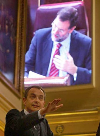 Rodríguez Zapatero, durante su intervención en el pleno. Al fondo, Mariano Rajoy, reflejado en la pantalla, prepara su réplica.