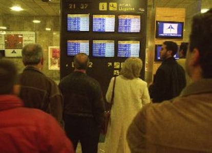 Un grupo de pasajeros comprueba los retrasos de algunos vuelos, ayer en Barajas.