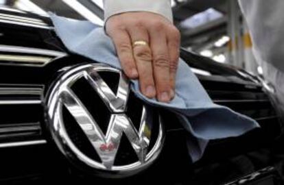 Un empleado saca brillo al logotipo de un coche Volkswagen (VW). EFE/Archivo