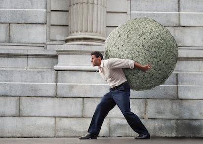 Businessman with large ball of money