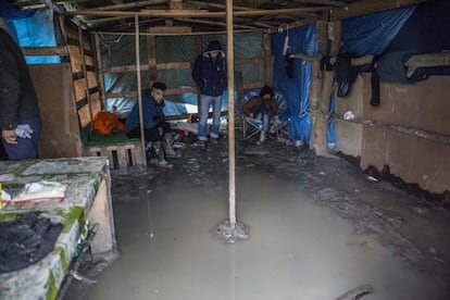 Una de las tiendes de campaña en la que viven hasta tres migrantes ha quedado totalmente inundada por el fuerte temporal del norte de Europa. Las botas de agua se han hecho prenda esencial para sobrevivir al lodo y el barro en el campo de Grande-Synthe (Francia).