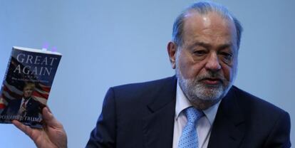 El millonario mexicano Carlos Slim con uno de los libros de Donald Trump en una conferencia.