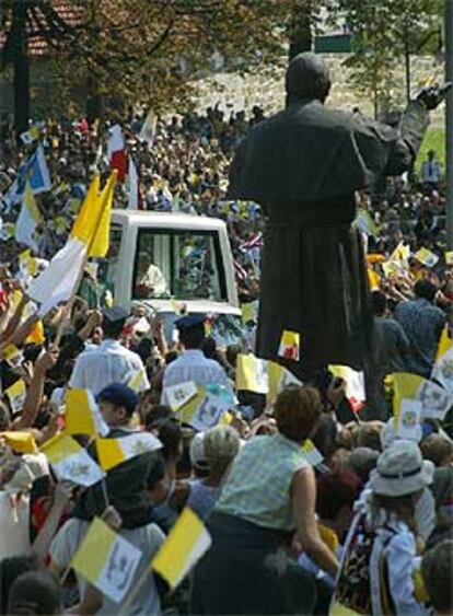 El Papa pasa junto a una estatua que le representa en las calles de Kalwaria.