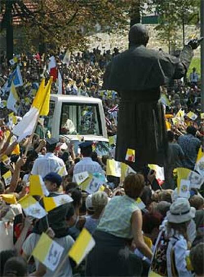 El Papa pasa junto a una estatua que le representa en las  calles de Kalwaria.