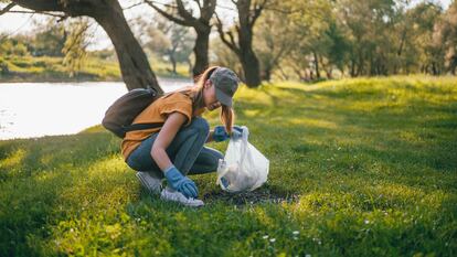 Young woman cleaning up garbage in the nature