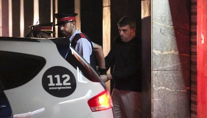 Agents traslladen el sospitós després de l'escorcoll al domicili.