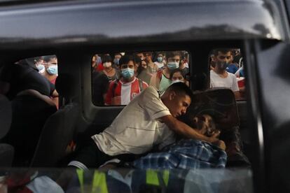 Una camioneta que lleva a una persona a un hospital pasa por una manifestación donde la gente protestaba.